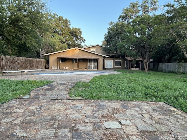 ranch-style house with a patio area, a front lawn, and an empty pool