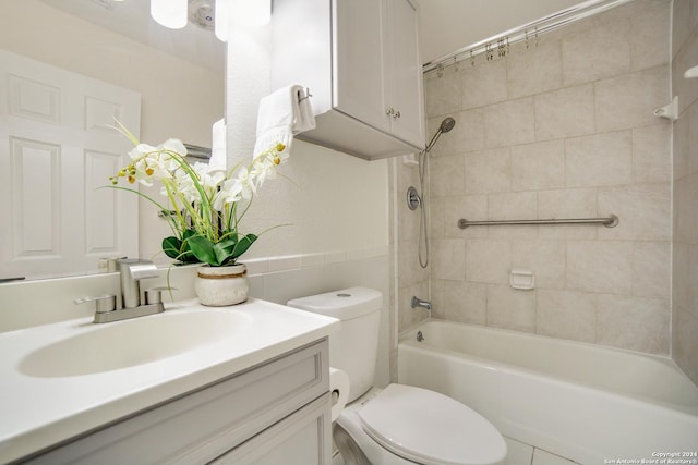 full bathroom with tile patterned flooring, vanity, tiled shower / bath combo, and toilet