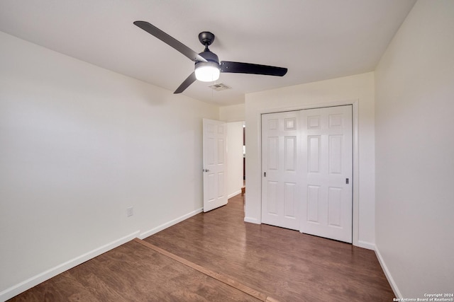 unfurnished bedroom featuring a closet, ceiling fan, and dark wood-type flooring