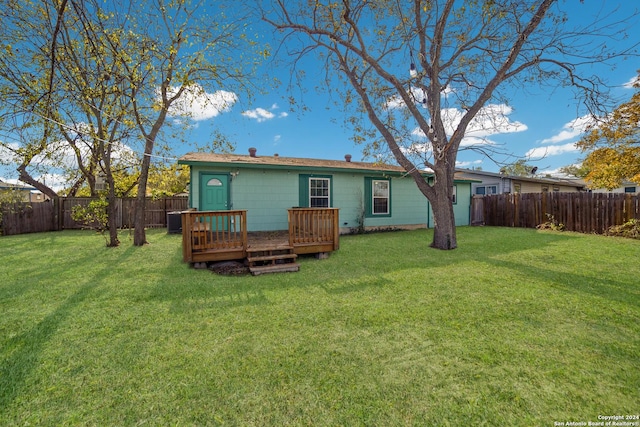 rear view of property featuring a deck and a yard