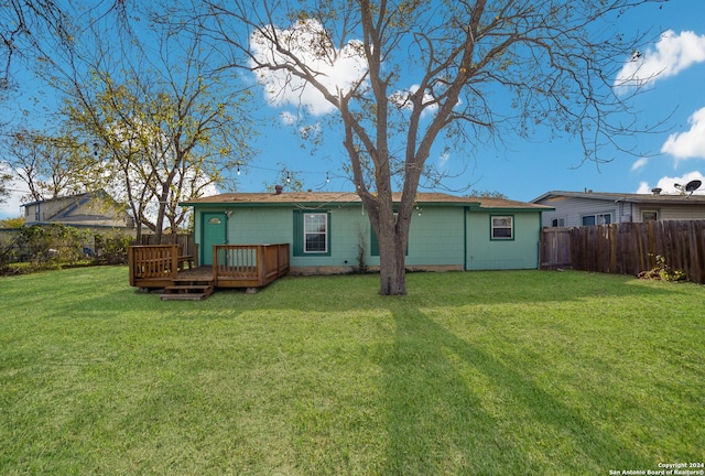 rear view of property with a lawn and a wooden deck