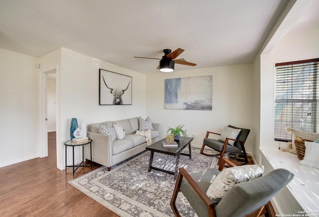 living room featuring ceiling fan, wood-type flooring, and a textured ceiling