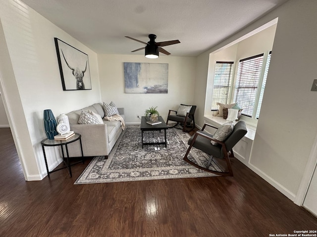 living room with ceiling fan, dark hardwood / wood-style flooring, and a textured ceiling