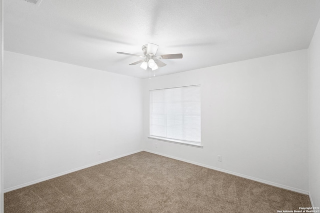 carpeted empty room with ceiling fan and a textured ceiling