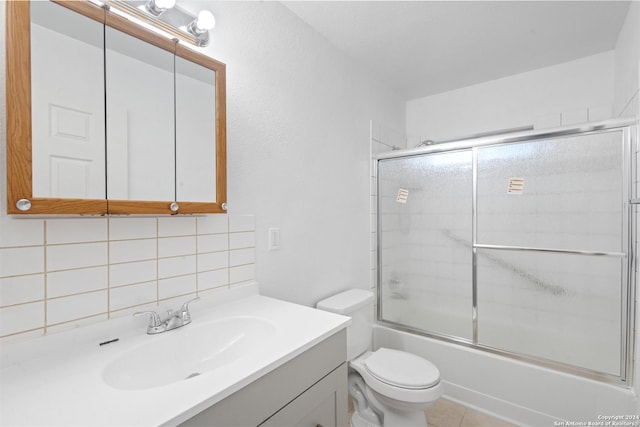 full bathroom featuring backsplash, tile patterned floors, bath / shower combo with glass door, vanity, and toilet