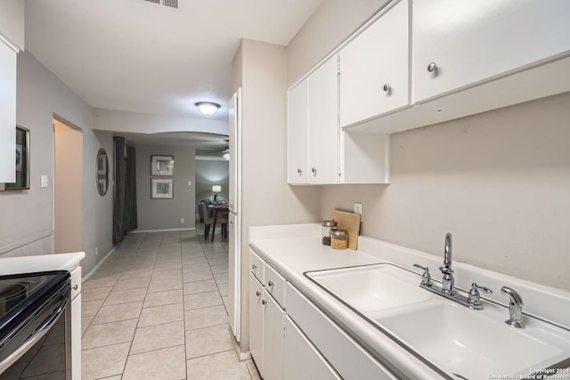 kitchen featuring white cabinets, sink, black electric range, ceiling fan, and light tile patterned floors