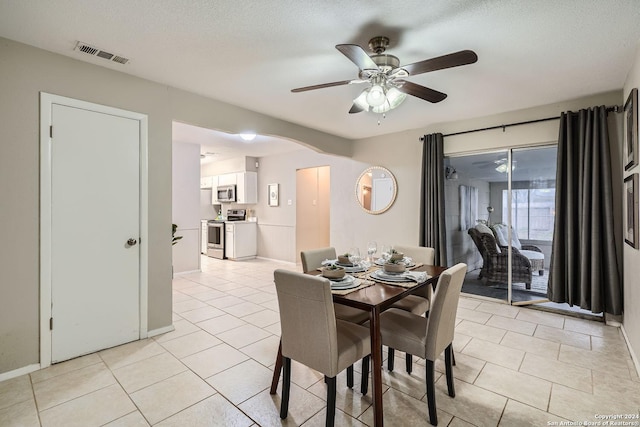 dining space with ceiling fan, light tile patterned floors, and a textured ceiling