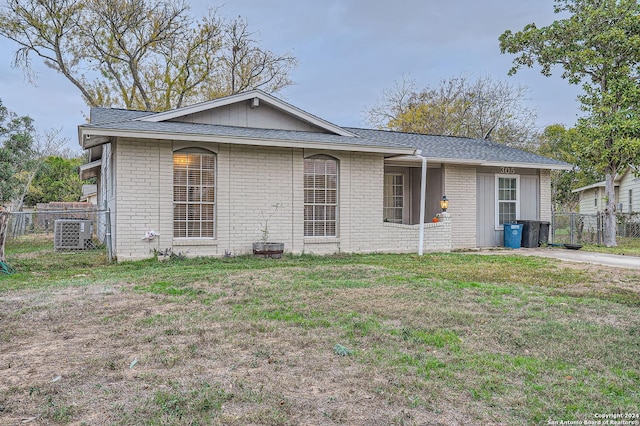 view of front of property with central AC unit and a front yard