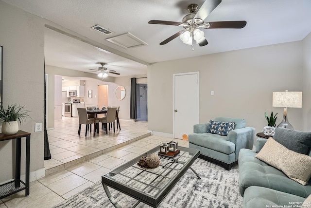 tiled living room with ceiling fan and a textured ceiling