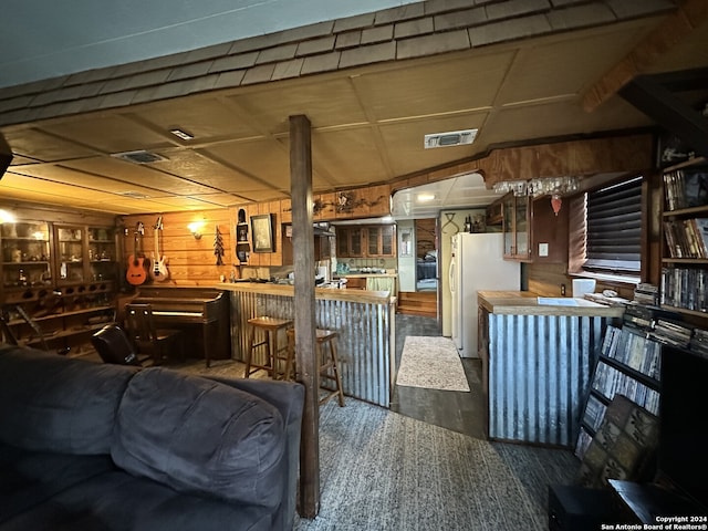 living room with bar, wood walls, and hardwood / wood-style flooring