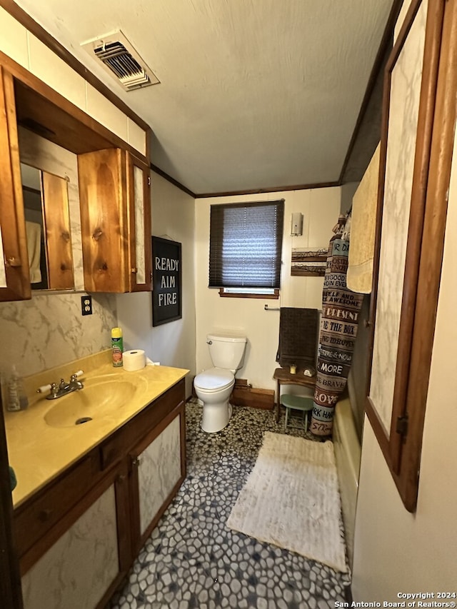 bathroom with sink, tile patterned flooring, toilet, ornamental molding, and a textured ceiling