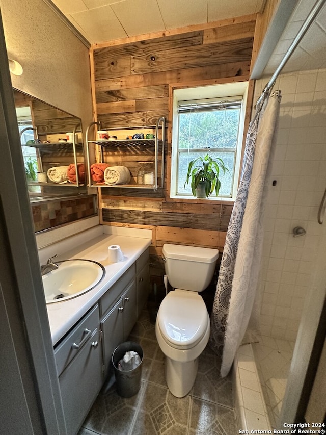 bathroom featuring vanity, toilet, curtained shower, and wooden walls