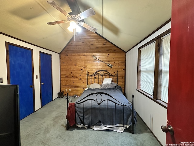 unfurnished bedroom with carpet, ceiling fan, wood walls, and lofted ceiling