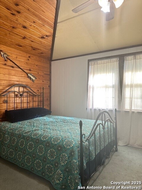 1306 Canyon Trce, Canyon Lake, TX 78133 - carpeted bedroom with lofted ceiling, wood walls, and a ceiling fan
