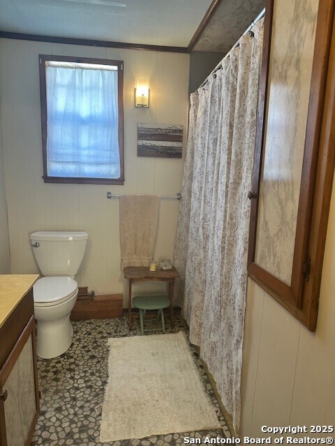 1306 Canyon Trce, Canyon Lake, TX 78133 - full bathroom with vanity, toilet, curtained shower, and a decorative wall