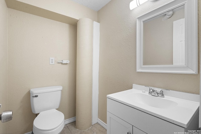 bathroom featuring tile patterned flooring, vanity, toilet, and a textured ceiling