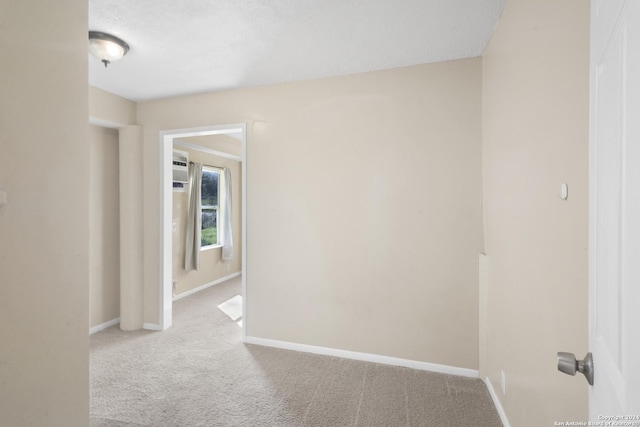 unfurnished room featuring light carpet and a textured ceiling