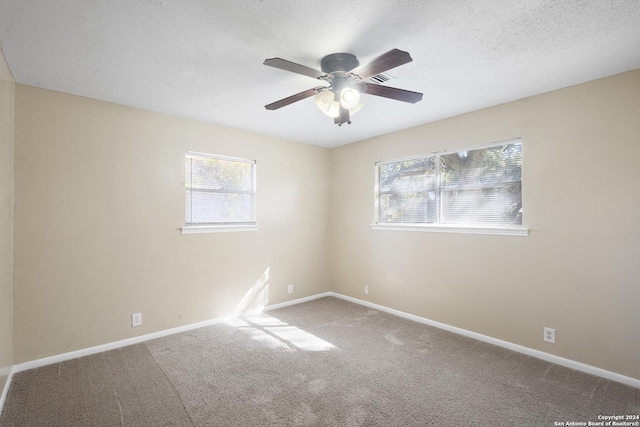 spare room with ceiling fan, carpet, and a textured ceiling