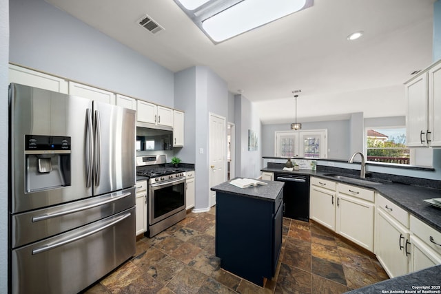 kitchen with appliances with stainless steel finishes, sink, hanging light fixtures, and a center island