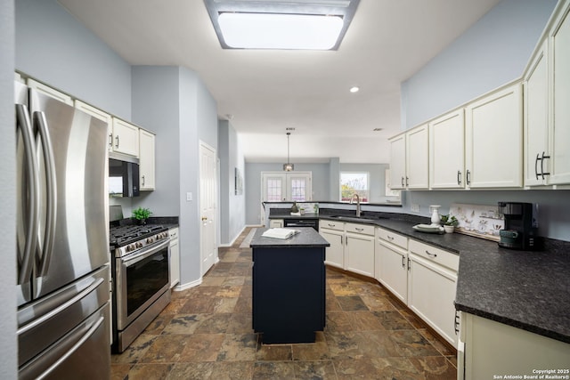 kitchen featuring sink, pendant lighting, appliances with stainless steel finishes, and a center island