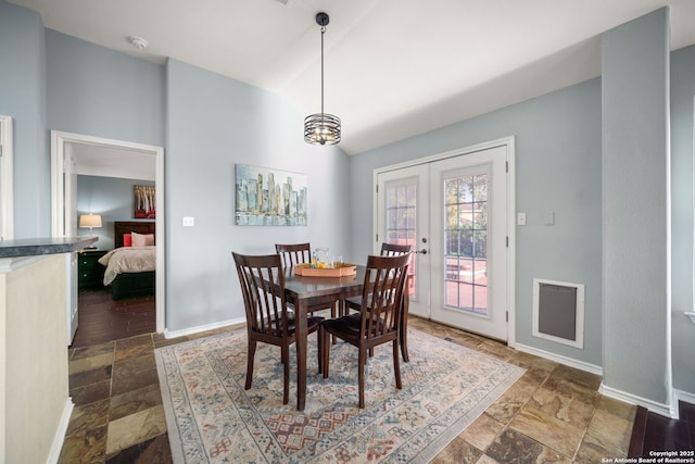 dining room with lofted ceiling, french doors, and a notable chandelier