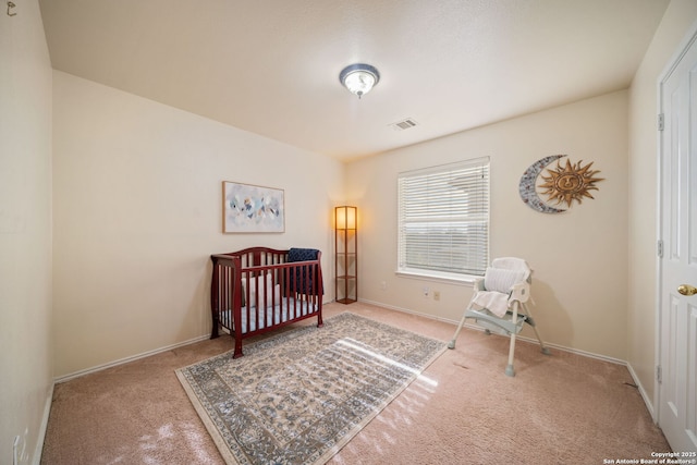 bedroom featuring carpet and a nursery area