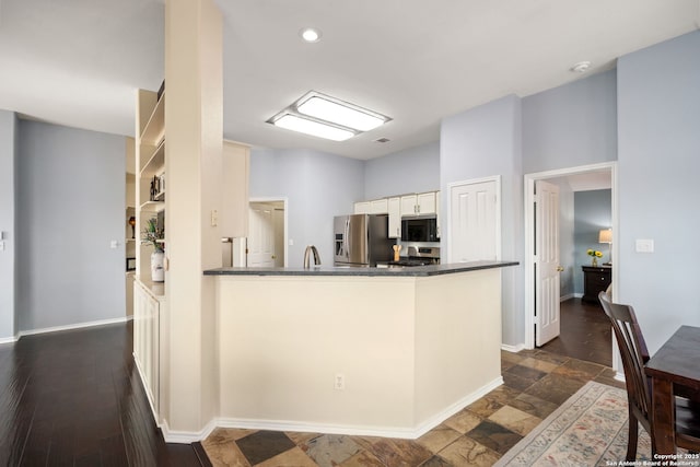 kitchen featuring kitchen peninsula, white cabinets, and stainless steel appliances