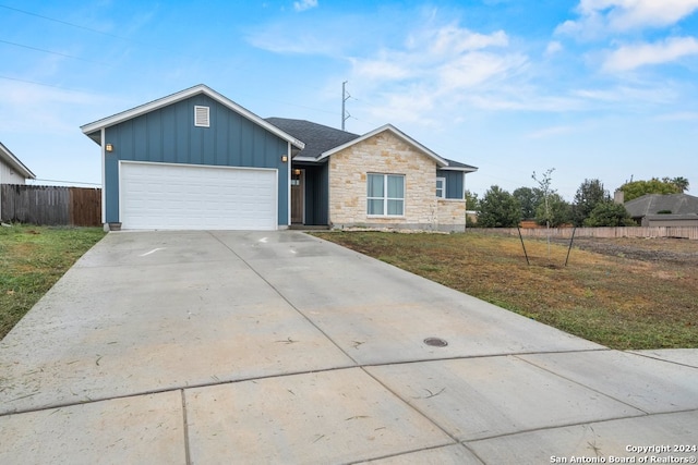 ranch-style home with a garage and a front lawn