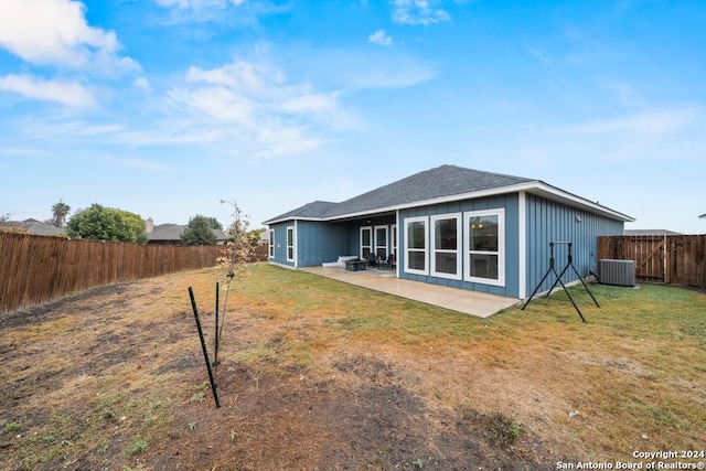 rear view of property featuring a lawn, a patio area, and central AC unit