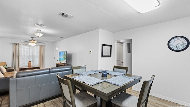 dining room featuring ceiling fan, light hardwood / wood-style floors, and a textured ceiling