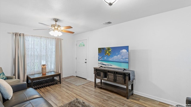 living room featuring light hardwood / wood-style flooring and ceiling fan