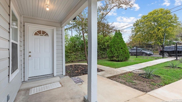 view of exterior entry featuring a lawn