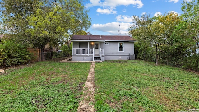 back of property featuring a lawn and cooling unit