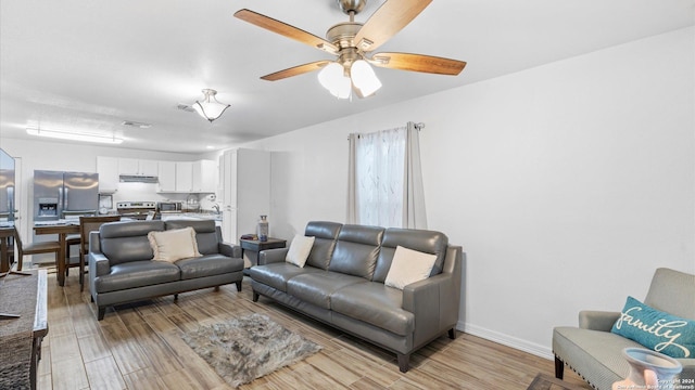 living room featuring ceiling fan and light hardwood / wood-style flooring