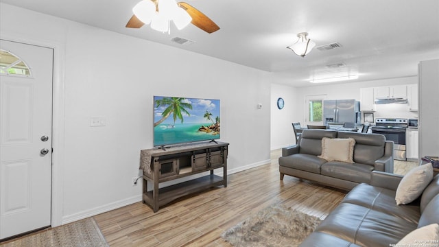 living room with ceiling fan and light wood-type flooring