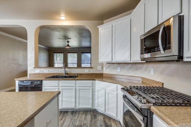 kitchen featuring ornamental molding, stainless steel appliances, sink, white cabinets, and light hardwood / wood-style floors