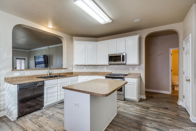 kitchen featuring appliances with stainless steel finishes, light wood-type flooring, white cabinetry, and sink