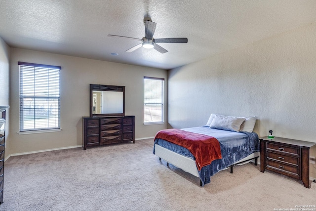 carpeted bedroom featuring a textured ceiling and ceiling fan