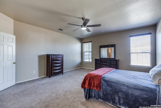 carpeted bedroom featuring a textured ceiling and ceiling fan