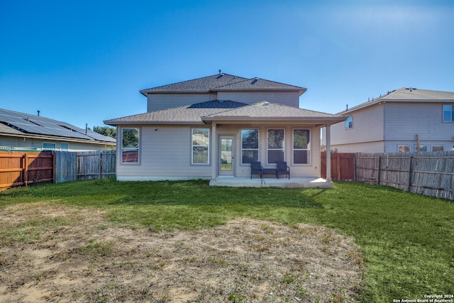 back of property with a yard and a patio