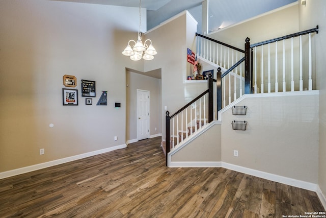 interior space featuring hardwood / wood-style flooring, a towering ceiling, and a chandelier