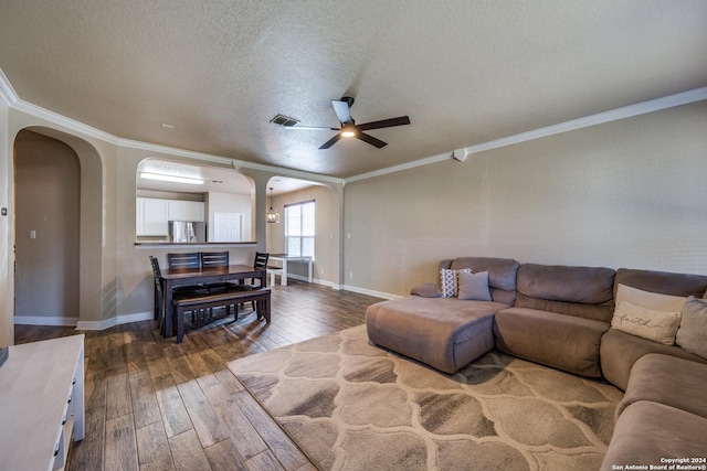 living room with a textured ceiling, hardwood / wood-style flooring, ceiling fan, and ornamental molding