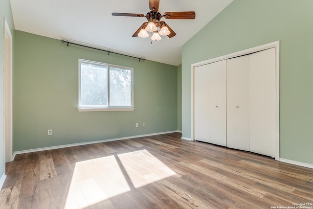 unfurnished bedroom with ceiling fan, a closet, vaulted ceiling, and light wood-type flooring