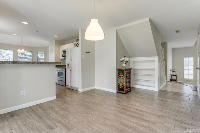 kitchen with light hardwood / wood-style floors, white cabinets, a healthy amount of sunlight, and appliances with stainless steel finishes