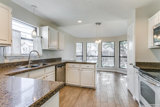 kitchen with stainless steel appliances, white cabinetry, and plenty of natural light