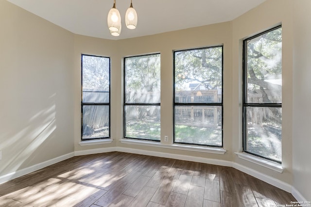 empty room with hardwood / wood-style flooring and a chandelier