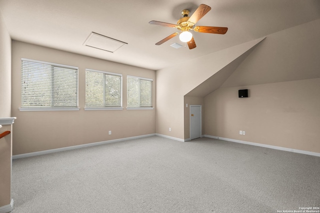 additional living space with ceiling fan, light colored carpet, and vaulted ceiling