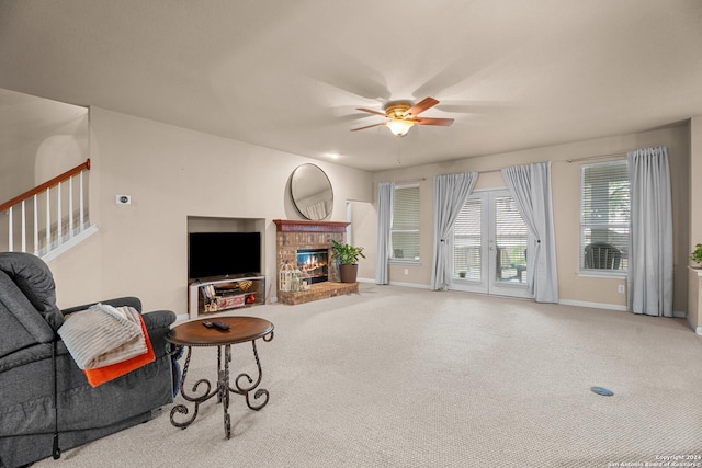 carpeted living room with ceiling fan and a brick fireplace