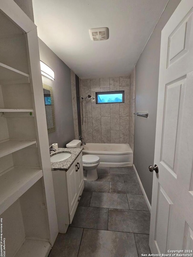 full bathroom featuring toilet, vanity, tiled shower / bath combo, and tile patterned flooring