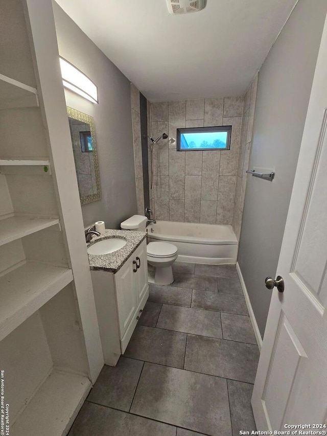 full bathroom with toilet, tile patterned floors, vanity, and tiled shower / bath combo